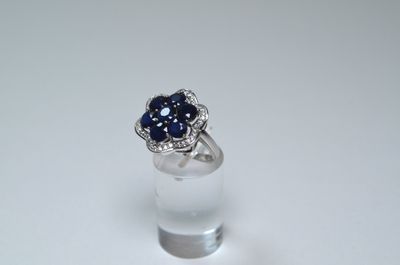 an image of a ring with a blue sapphire and diamonds on it