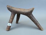 un vieux tabouret en bois posé sur une surface grise
