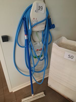 a blue hose attached to a wall next to a white bag