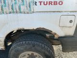 un camion blanc avec un gros pneu, garé sur le bord de la route