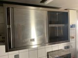 un four en acier inoxydable dans une cuisine aux murs carrelés de blanc