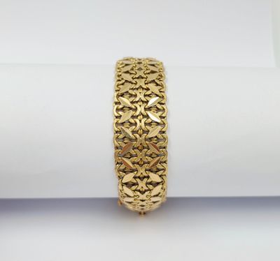 un gros plan d'un bracelet en or posé sur une serviette