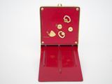 a red case with gold hearts on it on a white surface