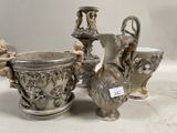 trois vases en argent posés l'un à côté de l'autre sur une table