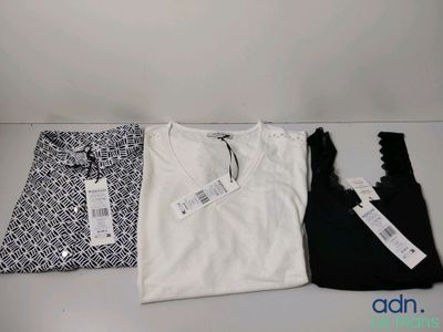 Trois t-shirts sont posés les uns à côté des autres sur une table.
