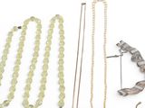 many different necklaces and earrings on a white surface