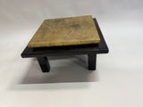 un gros plan sur une petite table en bois avec un plateau en marbre