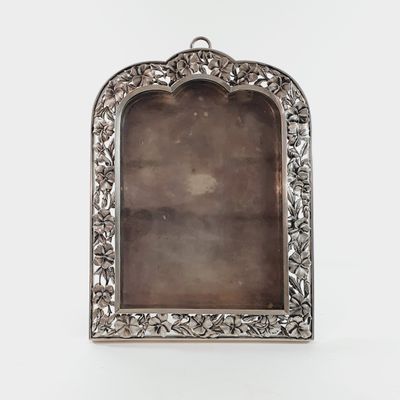 an antique silver picture frame with a floral design