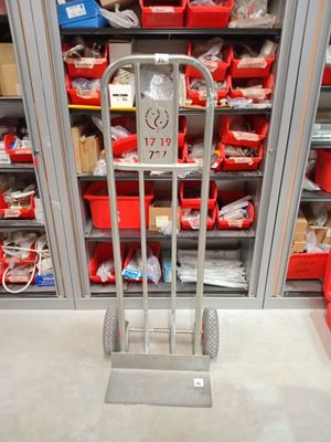 un chariot métallique au milieu d'une pièce remplie de bacs rouges