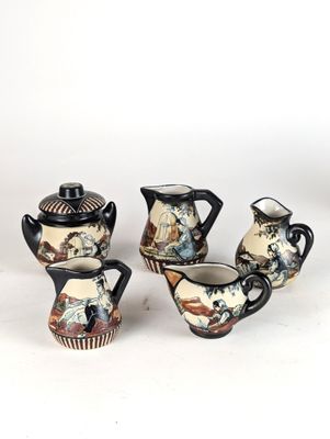three pieces of porcelain teapots and a cup on a white surface