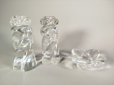 trois figurines en verre transparent posées sur une surface blanche