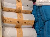 many bags of pillows and blankets stacked on top of each other