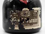 a bottle of liquor with a red rose on the top