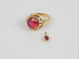 gros plan d'une bague en or avec une pierre en rubis