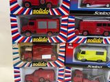 four red and yellow toy vehicles are in a display case