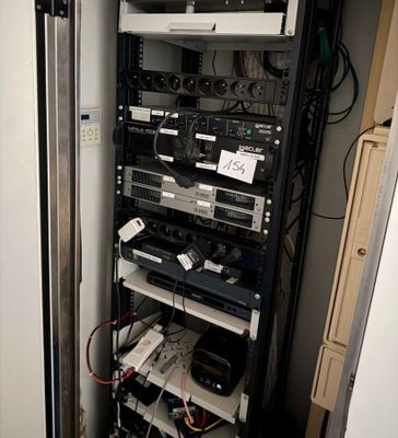 a rack with many electronics in it in a room