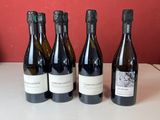 six bouteilles de vin sont alignées sur une table