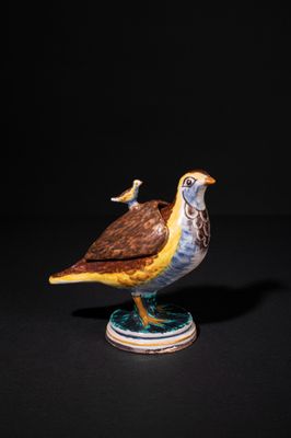 a close up of a figurine of a bird on a pedestal