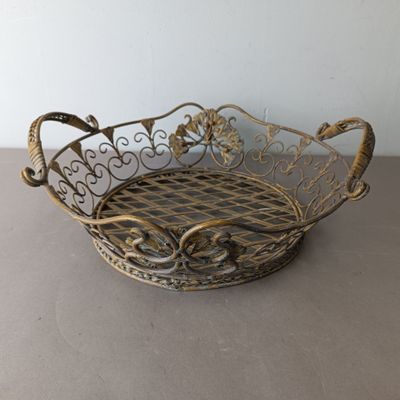 an antique brass basket with a checkered design on the bottom