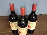 three bottles of wine sitting on top of a wooden table