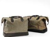 two brown and black bags sitting next to each other on a white surface