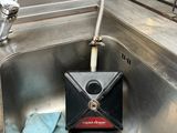 un évier en métal avec un distributeur de savon et une serviette bleue à l'intérieur