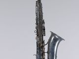 an old saxophone hanging from a string on a wall