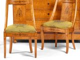 two chairs and a dresser with a marble top in a room