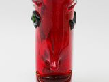 a red glass vase with a face on it