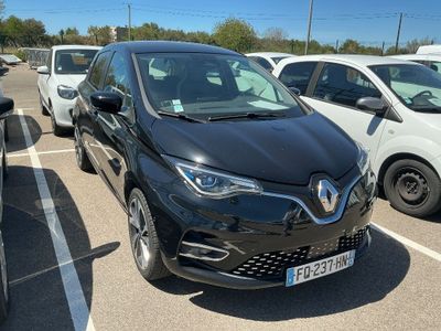 une voiture noire garée dans un parking à côté d'autres voitures