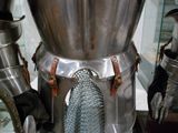 un gros plan sur une armure métallique exposée dans une vitrine