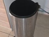 a trash can and a microwave on the counter