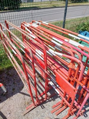 un tas de tuyaux rouges et blancs posés sur le bord de la route