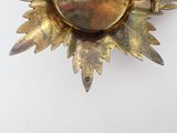 a gold brooch that has a picture of a sunflower on it