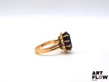 an image of a gold ring with a blue stone