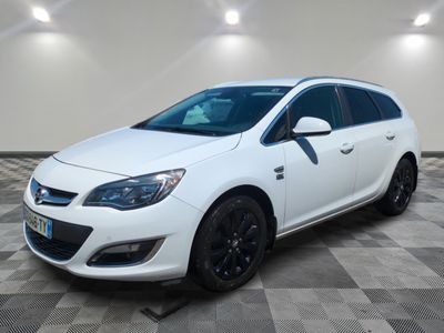 a white car is parked on a checkered floor in a garage