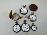 many different types of pocket watches on the table