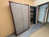 a closet in the corner of a room with a sliding door