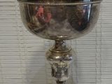 a silver bowl with a cross on it on a table