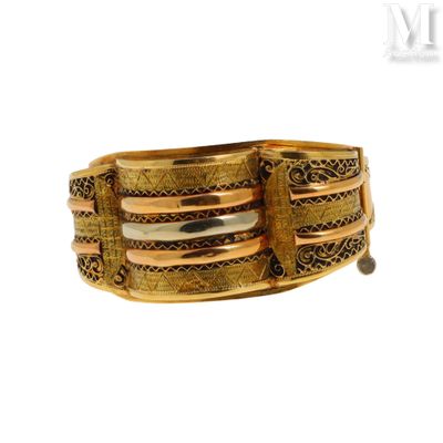 un gros plan sur un bracelet en or orné d'une perle noire