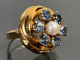 une bague en or sertie d'une perle et de pierres bleues