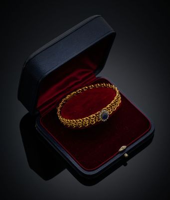 un gros plan sur un bracelet en or dans un écrin en velours rouge