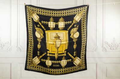 a black and gold scarf hanging on the wall