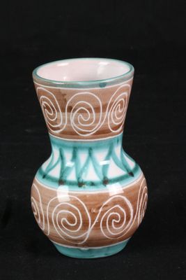 un petit vase posé sur une surface noire