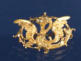 une broche en or représentant un dragon sur un fond bleu