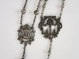 a close up of a necklace with pearls and a clasp