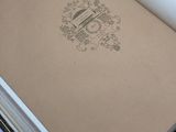 an open book with a brown cover sitting on top of a white table