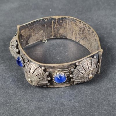 un gros plan sur un bracelet en argent orné de pierres bleues