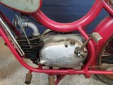 a red motorcycle parked in front of a blue wall