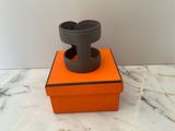une boîte orange surmontée d'une bague, posée sur une surface en marbre